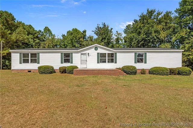 a view of a house with backyard and plants