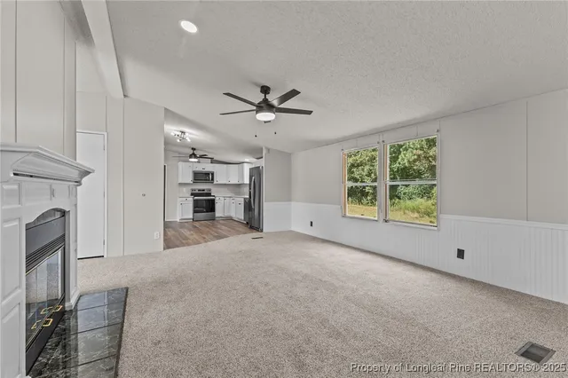 an empty room with windows and fireplace