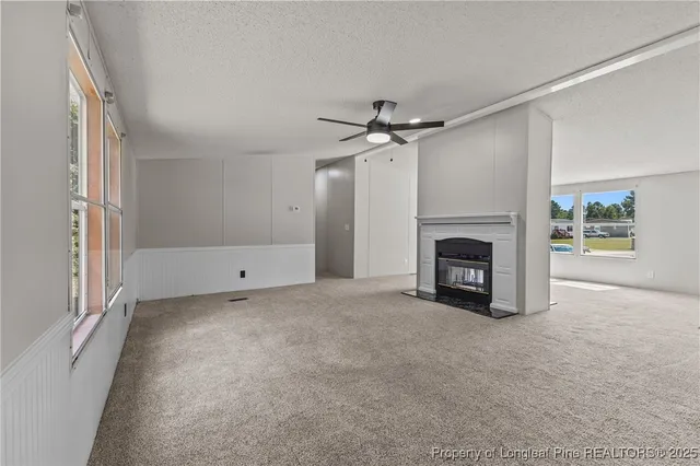 an empty room with windows fire place and a fireplace