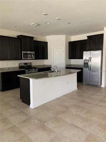 a kitchen with stainless steel appliances a sink a stove a microwave a counter top space and cabinets