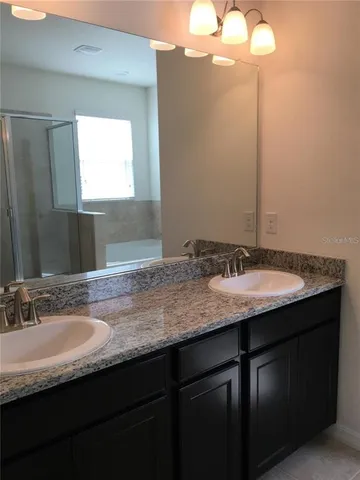 a bathroom with a granite countertop sink a mirror and double