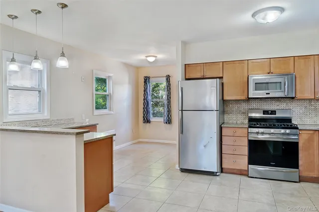 a kitchen with stainless steel appliances granite countertop a refrigerator stove and sink