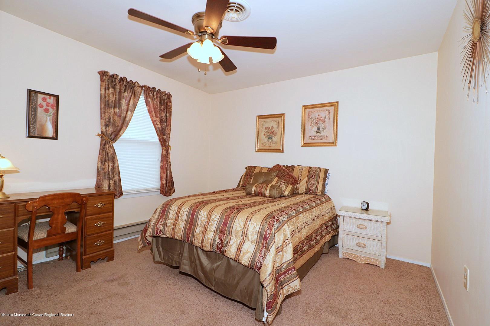 34 B Mill Road Whiting, NJ 08759 - Photo 15 of 22 a bedroom with a bed and a chandelier