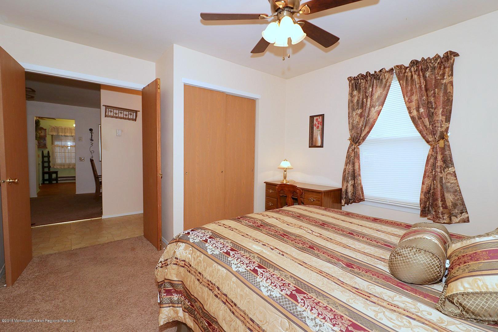 34 B Mill Road Whiting, NJ 08759 - Photo 16 of 22 a bedroom with a bed and a chandelier