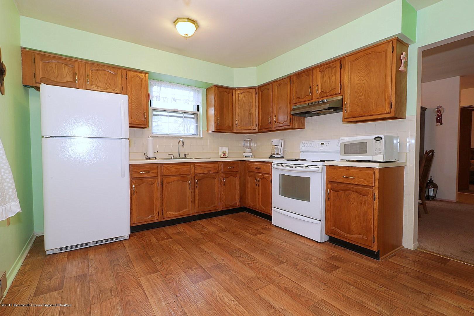 34 B Mill Road Whiting, NJ 08759 - Photo 7 of 22 a kitchen with wooden floors and white stainless steel appliances