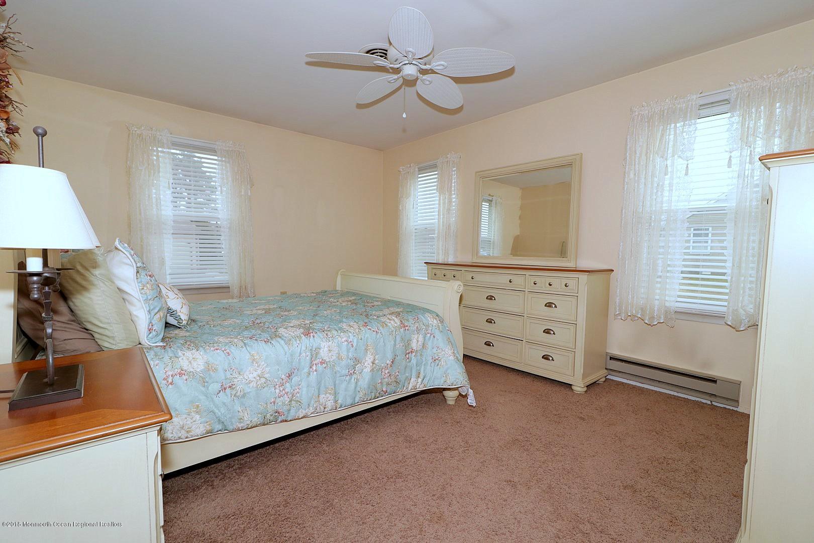 34 B Mill Road Whiting, NJ 08759 - Photo 10 of 22 a bedroom with a bed and a chandelier