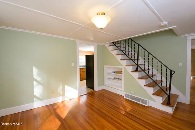a view of entryway and hall with wooden floor