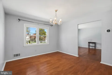a view of a livingroom with a window and wooden floor