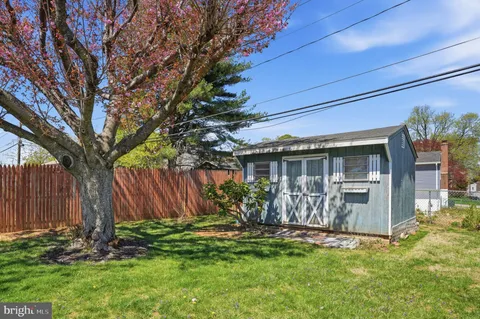 a view of a house with backyard and a tree