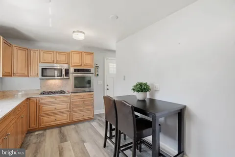 a kitchen with stainless steel appliances a dining table chairs and granite counter tops