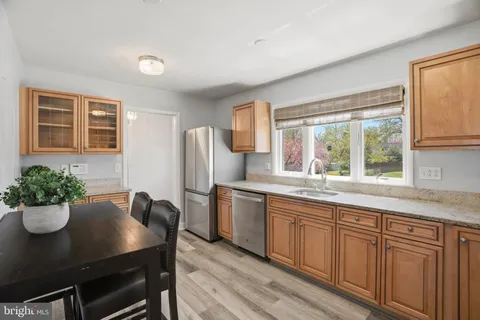 a kitchen with stainless steel appliances granite countertop a kitchen island hardwood floor sink stove and dining table