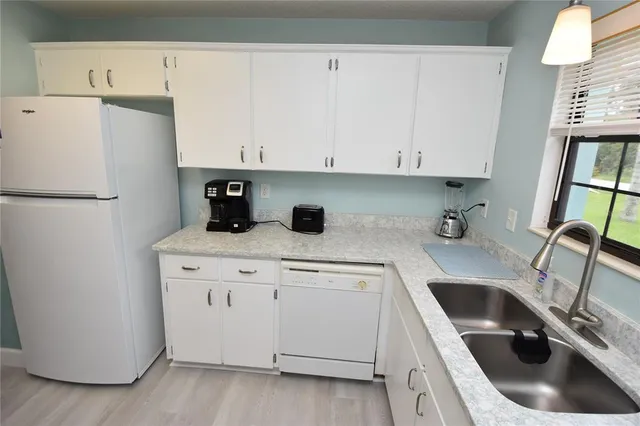 a kitchen with a refrigerator sink and cabinets