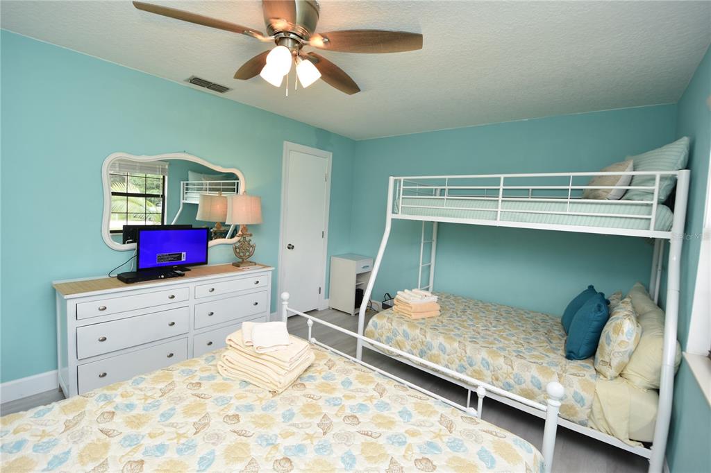 59 Fallen Oak Lane Palm Coast, FL 32137 - Photo 27 of 35 a bedroom with a bed and a chandelier fan