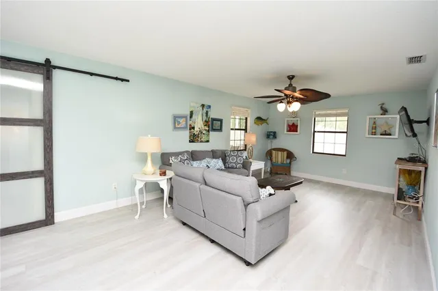 a living room with furniture a desk and chair with the wooden floor