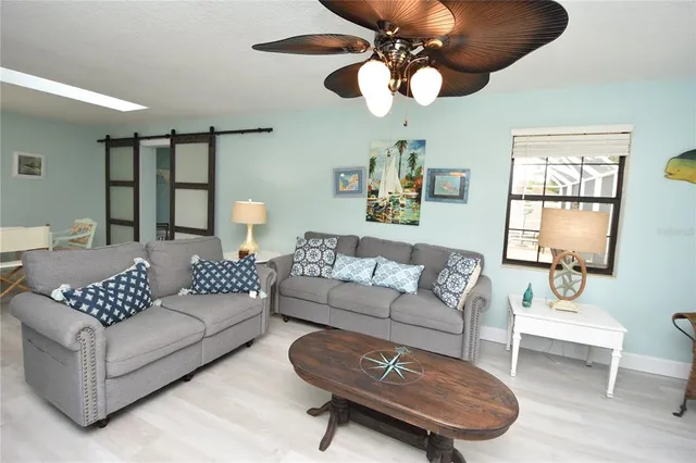 a living room with furniture ceiling fan and a window