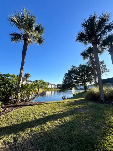 an empty room with a chandelier fan and windows