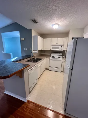 a view of kitchen with wooden floor and electronic appliances