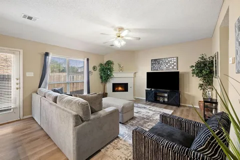 a living room with furniture a flat screen tv and a large window