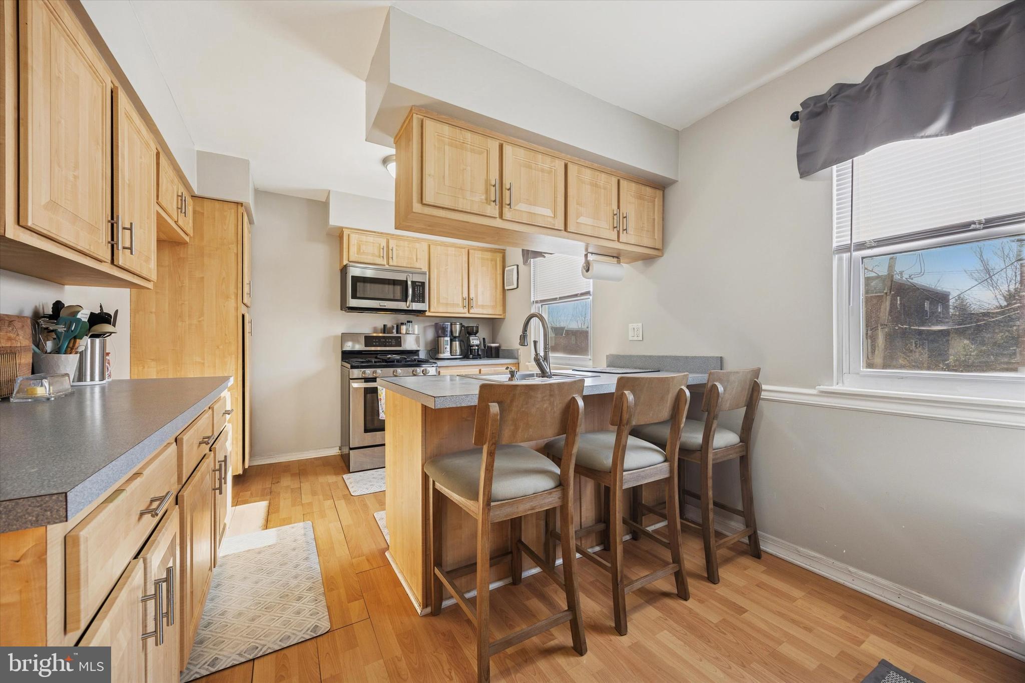 7011 Matthias Street Philadelphia, PA 19128 - Photo 7 of 28 a dining room with stainless steel appliances kitchen island granite countertop a table chairs and a refrigerator
