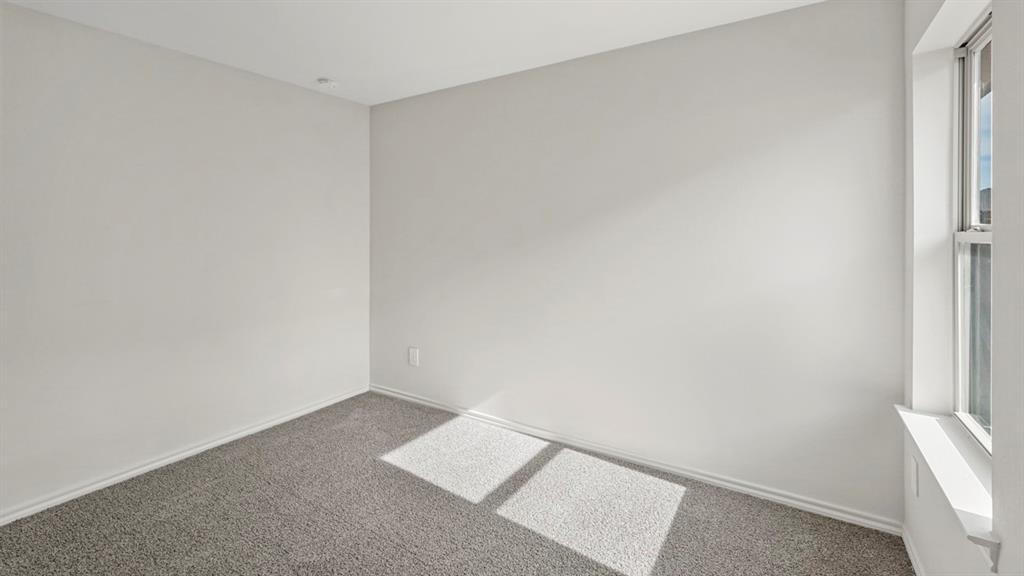 1969 Freeman Street Tyler, TX 75704 - Photo 24 of 30 Room featuring neutral gray walls, gray carpeting, white baseboards, and a single-pane window with a white frame