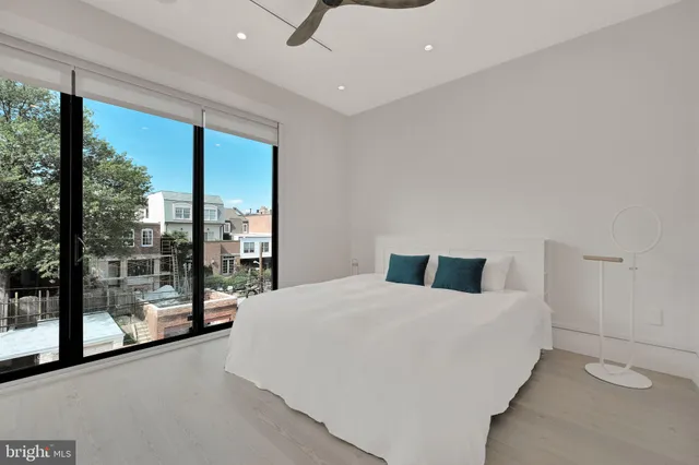 a bedroom with a bed and a large window