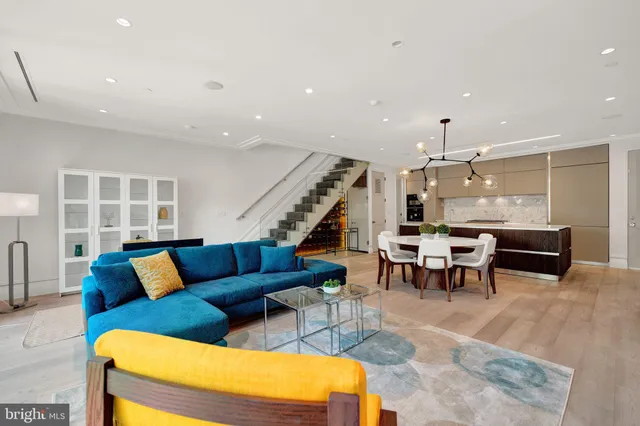 a large white kitchen with a large center island and stainless steel appliances