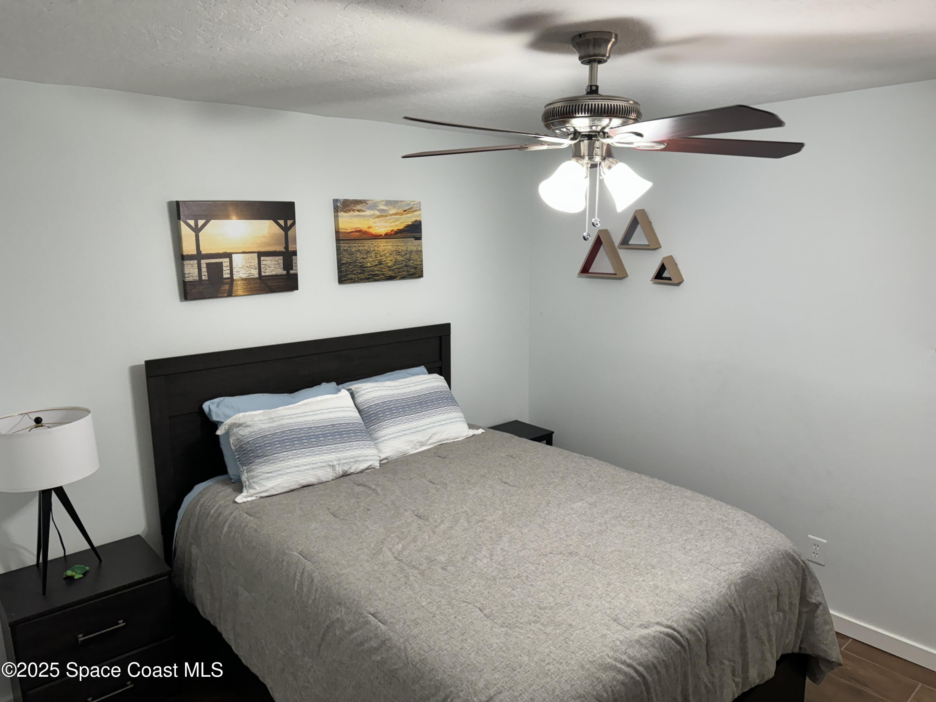 2130 South Patrick Drive Indian Harbour Beach, FL 32937 - Photo 11 of 14 a bedroom with a bed and a chandelier