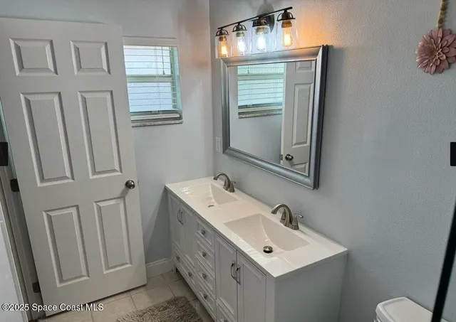 a bathroom with a sink a toilet and mirror
