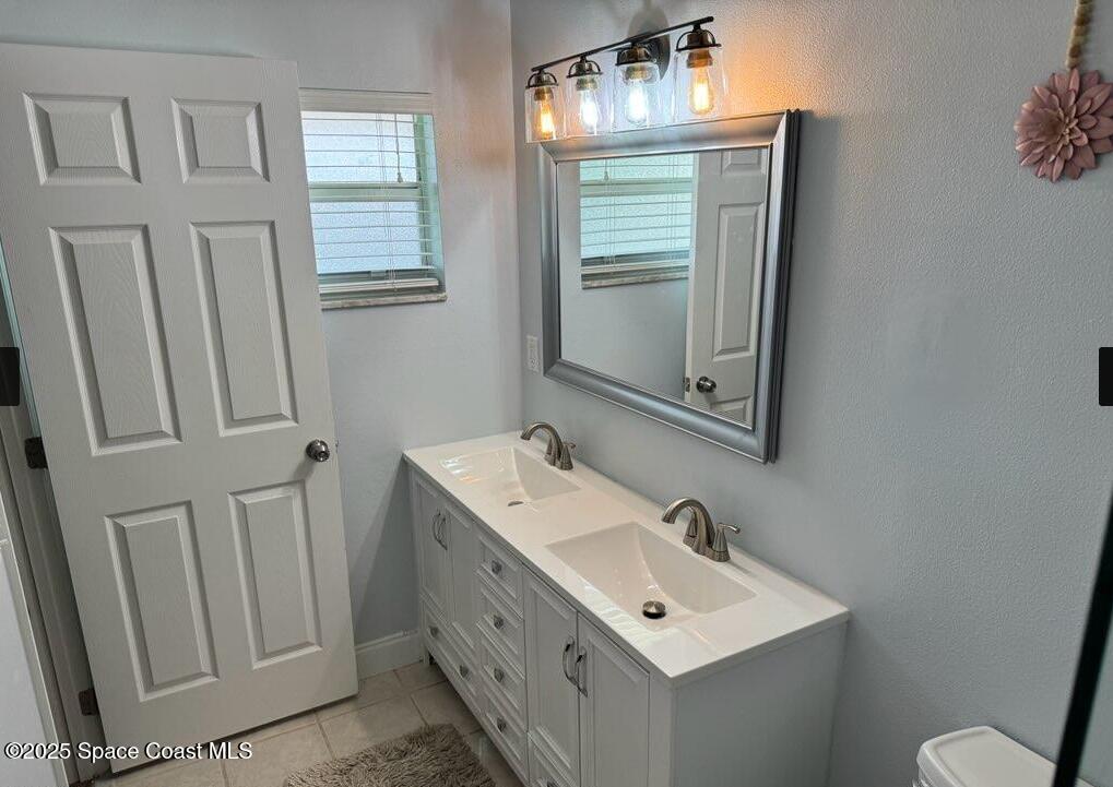 2130 South Patrick Drive Indian Harbour Beach, FL 32937 - Photo 6 of 14 a bathroom with a sink a toilet and mirror