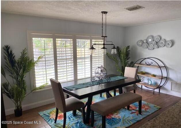 2130 South Patrick Drive Indian Harbour Beach, FL 32937 - Photo 8 of 14 a view of a dining room with furniture window and wooden floor