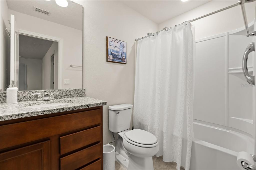5192 Chickadee Street St. Cloud, FL 34771 - Photo 26 of 35 a bathroom with a granite countertop sink toilet and shower