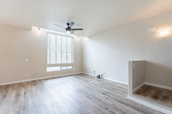 a view of a livingroom with a ceiling fan and wooden floor