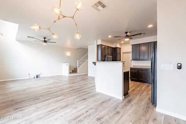 a kitchen with stainless steel appliances kitchen island granite countertop a sink refrigerator and cabinets