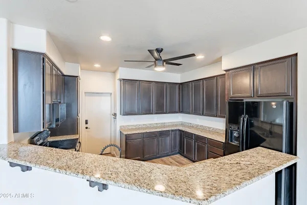 a kitchen with granite countertop a refrigerator stove top oven and sink