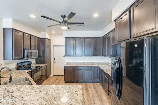 a kitchen with stainless steel appliances granite countertop a sink stove and refrigerator