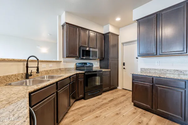 a kitchen with kitchen island granite countertop a sink stainless steel appliances and cabinets