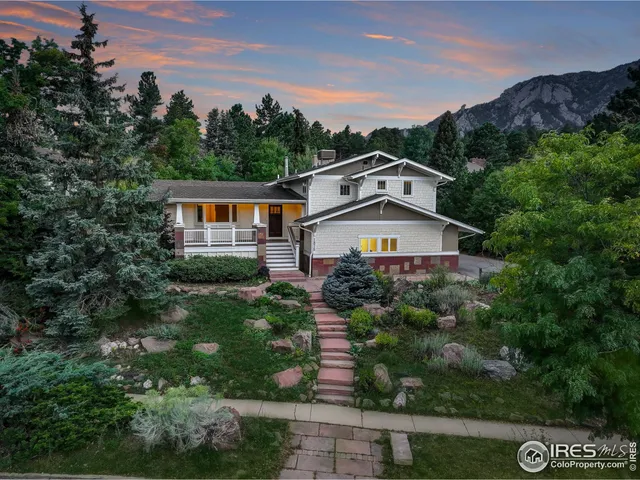 a view of a big house with a big yard and large trees
