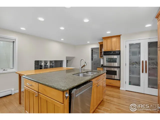 a kitchen with stainless steel appliances granite countertop a sink and a refrigerator