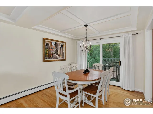 a dining room with furniture a chandelier and wooden floor