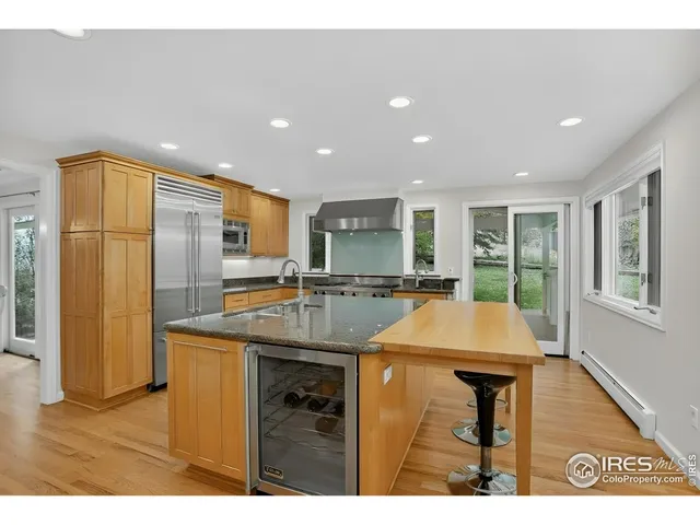 a kitchen with stainless steel appliances granite countertop a sink and a refrigerator