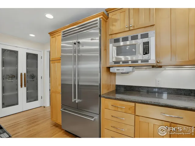 a kitchen with stainless steel appliances granite countertop a refrigerator and a sink