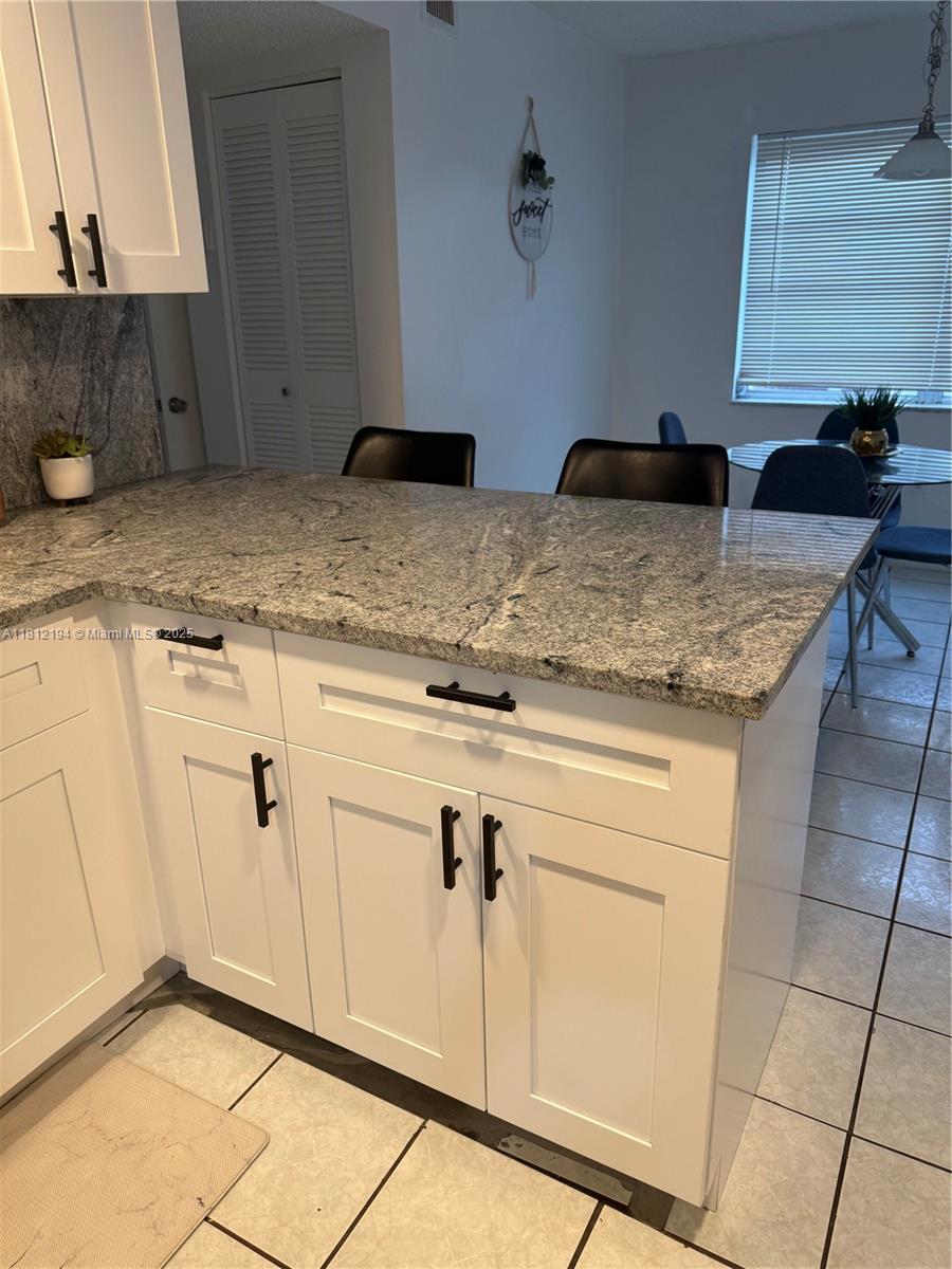 10661 Southwest 108th Avenue, Unit 2E Miami, FL 33176 - Photo 11 of 25 a kitchen with granite countertop white cabinets and white appliances