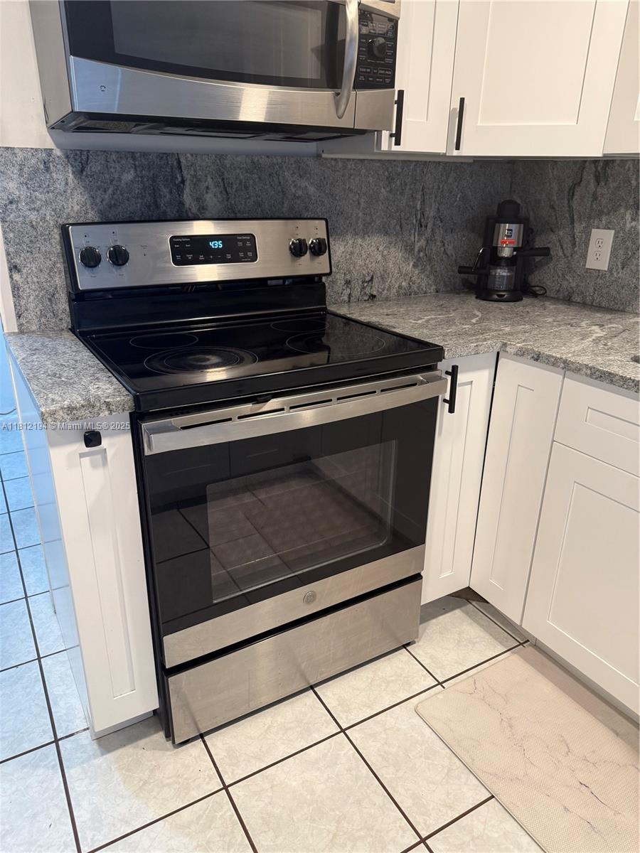 10661 Southwest 108th Avenue, Unit 2E Miami, FL 33176 - Photo 12 of 25 a stove top oven sitting inside of a kitchen