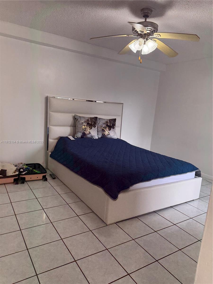 10661 Southwest 108th Avenue, Unit 2E Miami, FL 33176 - Photo 15 of 25 a bedroom with a bed and a chandelier