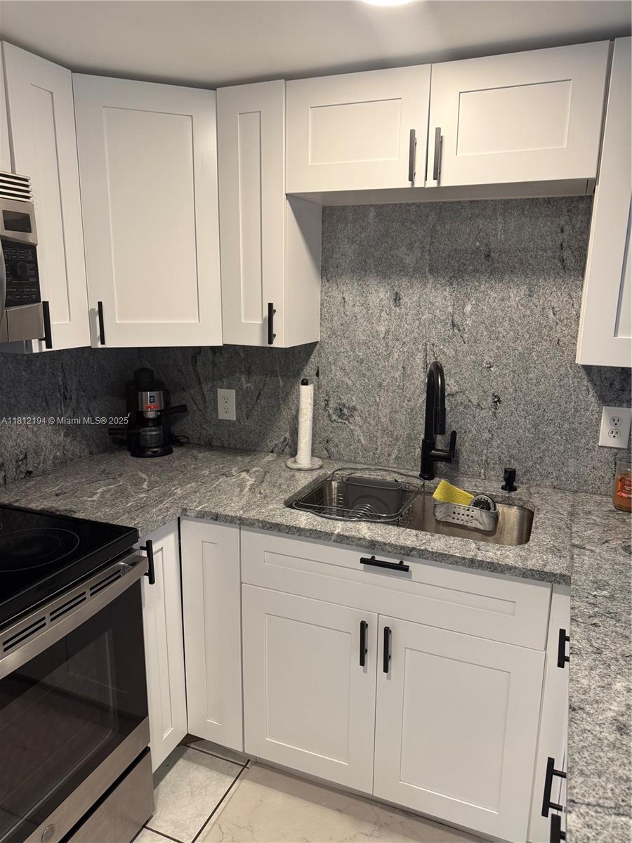 10661 Southwest 108th Avenue, Unit 2E Miami, FL 33176 - Photo 10 of 25 a kitchen with white cabinets and a sink