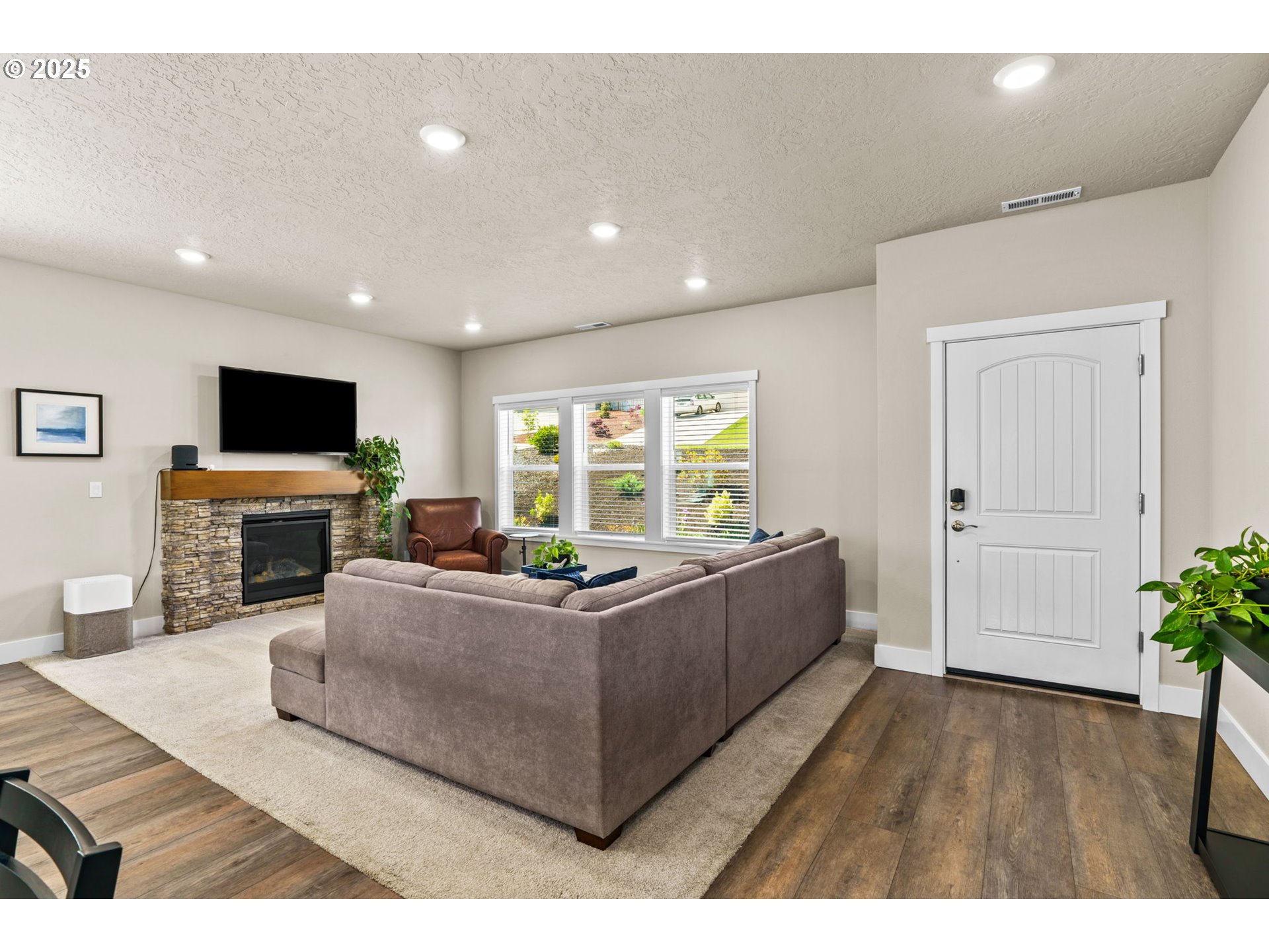 3740 Rockcress Road Eugene, OR 97403 - Photo 6 of 47 a living room with furniture a flat screen tv and a fireplace