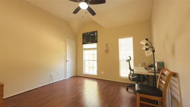 a view of a room with wooden floor fan and windows