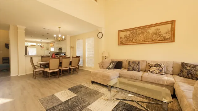 a living room with furniture and a dining table with rug