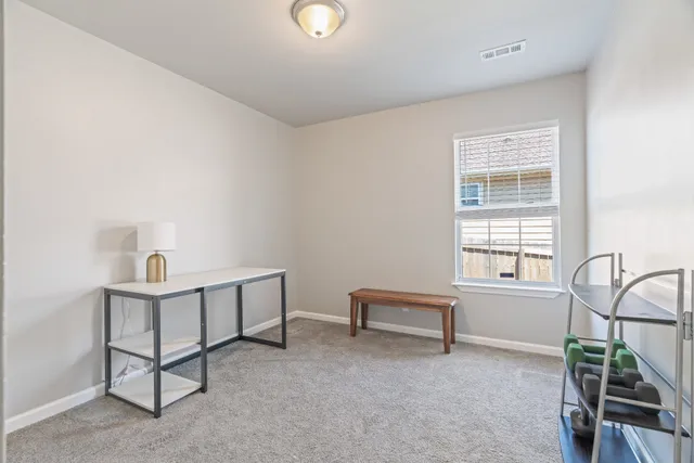 a view of a workspace with furniture and a window