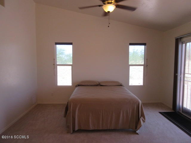 1881 Via Ochoa Rio Rico, AZ 85648 - Photo 40 of 44 a bedroom with a bed and a chandelier
